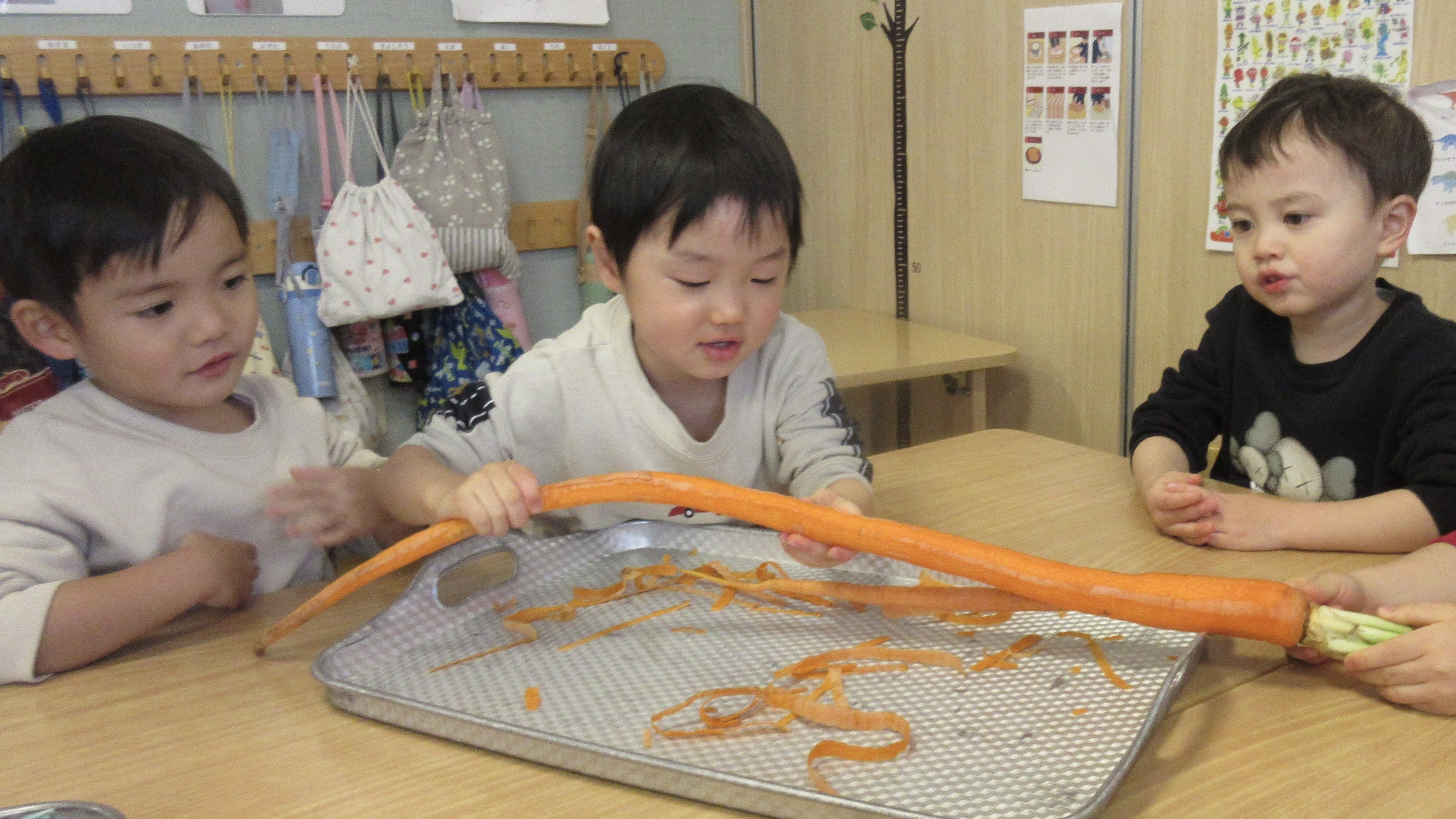ながいにんじんに触れるこどもたち